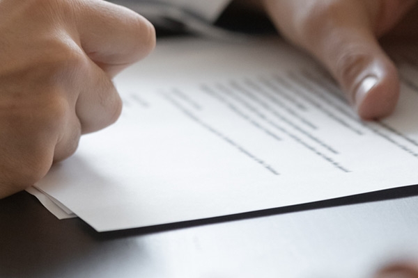 hands signing business document